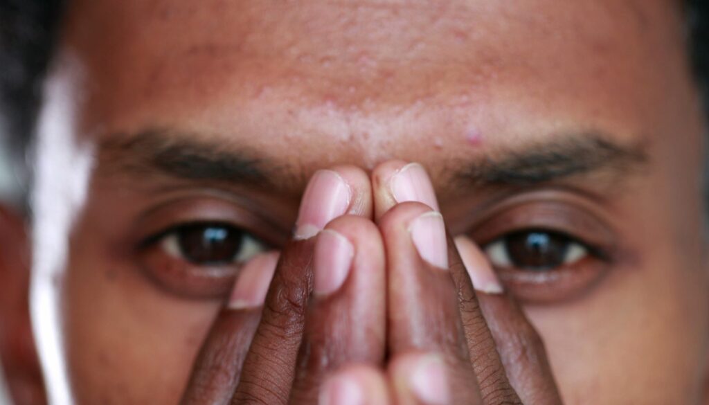 hispanic man with hands on face practicing emdr therapy