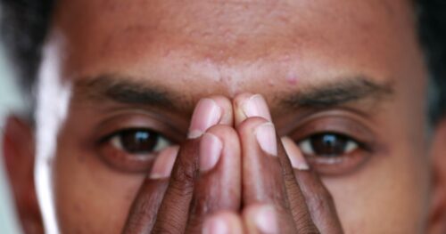 hispanic man with hands on face practicing emdr therapy