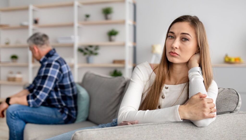 woman sitting on opposite end of couch as partner_mental health